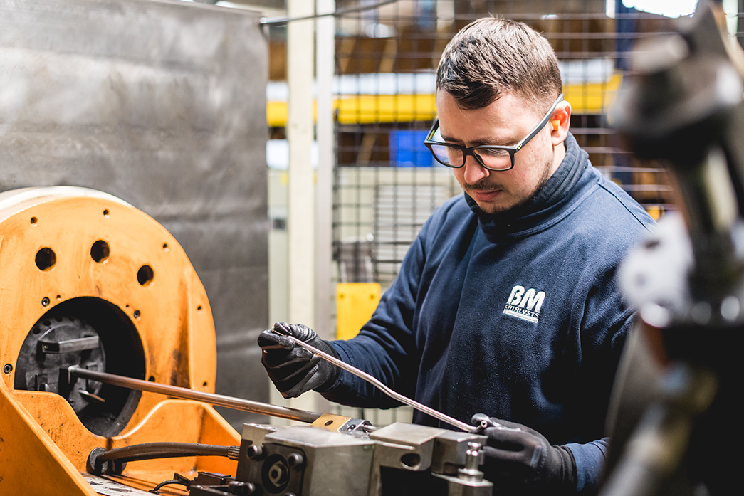 A BM Catalyst worker is inspecting a product part in the warehouse