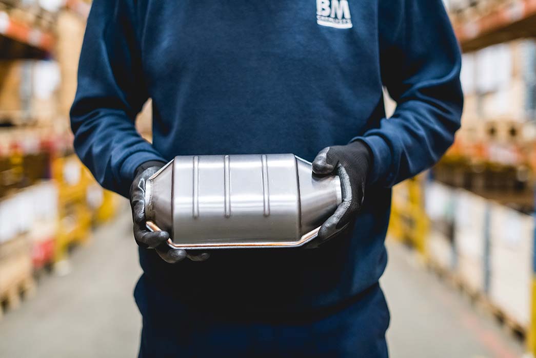 A BM Catalysts worker is holding a product part